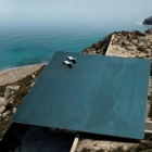 Maison Piscine à débordement unique sur le toit flottant au-dessus d'un paysage sauvage île grecque 